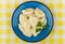 Dumplings with parsley in blue glass plate on yellow tablecloth