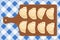 Dumplings pierogi, varenyky, pelmeni on a wooden cutting board on blue checkered tablecloth. Vector hand drawn illustration.
