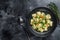 Dumplings Soup with Ravioli pasta in a bowl with greens. Black background. Top view. Copy space