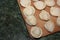 Dumplings on a wooden board on a green background. Top view on a green table with homemade food. Uncooked handmade dumplings on a