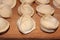 Dumplings on a wooden board. Top view on wooden table with homemade food. Uncooked handmade dumplings on a wooden plate