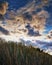 Dune under a dramatic sky with clouds and sunshine in the background on the beach