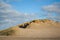 Dunes with a blue sky and grey clouds