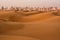 Dunes of Desert at dawn and skyscrapers of  Dubai United Arab Emirates