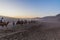 DUNHUANG, CHINA - AUGUST 21, 2018: Tourists ride camels at Singing Sands Dune near Dunhuang, Gansu Province, Chi