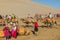 DUNHUANG, CHINA - AUGUST 21, 2018: Tourists ride camels at Singing Sands Dune near Dunhuang, Gansu Province, Chi