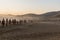 DUNHUANG, CHINA - AUGUST 21, 2018: Tourists ride camels at Singing Sands Dune near Dunhuang, Gansu Province, Chi