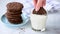 Dunking chocolate cookie in glass of milk