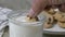 Dunking a piece of a chocolate chip cookie in a glass of milk