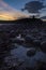 Dunstanburgh castle silhouetted at sunrise on the Northumberland coast