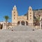 Duomo di Cefalu of the famous unesco heritage church in Cefalu, flowerpots decorate the stairs the famous rock Rocca di Cefalu