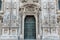 Duomo of Milan, Italy. Detail of facade and main entrance door to the cathedral of Milan in Duomo Square