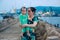 Duong Dong city, Phu Quoc, Vietnam - December 2018: vietnamese woman with small child on breakwater in harbor.