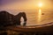 Durdle Door rock formation in the sea on the south coast of England during sunset