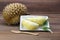 Durian fruits and yellow flesh durian on white dish with durian leaf, wooden background.