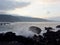 Dusk Along Rocky Shore with waves crash along rocks and clouds in the sky