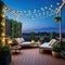 At dusk in the a comfortable rooftop patio area with a lounging a hanging and string lights is