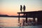 Dusk couple silhouette on pier at sea water. dusk couple silhouette walk at sunset sea resort.