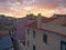 Dusk falls on the historic district of Mouraria in Lisbon, Portugal with a vivid sunset.