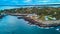 Dusk light aerial over coast of Maine with rocky cliffs and homes