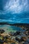 Dusk over ocean volcanic rock pool on a cloudy sky