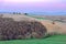 Dusk scenery of a lovely church The Chapel of Our Lady of Vitaleta  standing on a grassy hillside with forests in foreground in