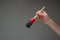 Dusting brush with wooden handle held by male hand. Close up studio shot,  on gray background