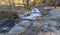 Dusting of snow next to a stream with ice