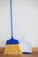 Dustpan and sweeping broom leaning against white wall