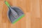 Dustpan and sweeping brush on wooden floor