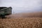 Dusty combine harvester on dry, reaped wheat crop