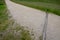 Dusty gravel forest road made of yellow sand and stones with transverse drainage metal gutters for water drainage