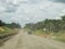 Dusty gravel road with cars during day time.