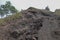 Dusty trail with lava slag and rocks to the top of Batur volcano. Road Extreme terrain to the mountain. Footpath around crater