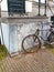 Dutch bicycles parked abandoned on the wall of a house with the anti theft security chain along the sidewalk