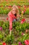 Dutch blond girl picking flowers in tulips field