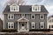 dutch colonial facade with enhanced dormer windows under gray sky