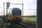 Dutch double decks commuter in Moordrecht between Gouda and Moordrecht at railroad crossing