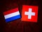 Dutch flag with Swiss flag on a tree stump isolated