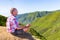 Dutch man meditating on mountain near green valley