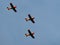 Dutch old training planes flying in formation in blue sky.