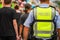 Dutch policeman wearing a yellow & x22;police& x22; west standing in a crowd of people outside