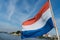 Dutch red, white and blue striped flag in breeze on stern of boa