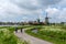 Dutch senior citizens enjoy a bicycle ride along the canals of North Holland with traditional windmills in the background