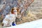 Dutch Spaniel Kooiker Hound sits near a large pine tree in a park