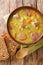 Dutch Split Pea Soup Erwtensoep with vegetables, sausages and pork closeup in the plate. vertical top view