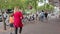 Dutch street with bicycles locked on stands, pedestrians walking on the pavement and car traffic driving on the road