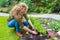 Dutch teenage girl planting parsley in garden soil