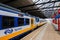 Dutch train leaves railway station Schiedam, Netherlands