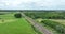 Dutch train passing commuting traveling in forrest grassland nature landscape. Sustainable travel technology by rail